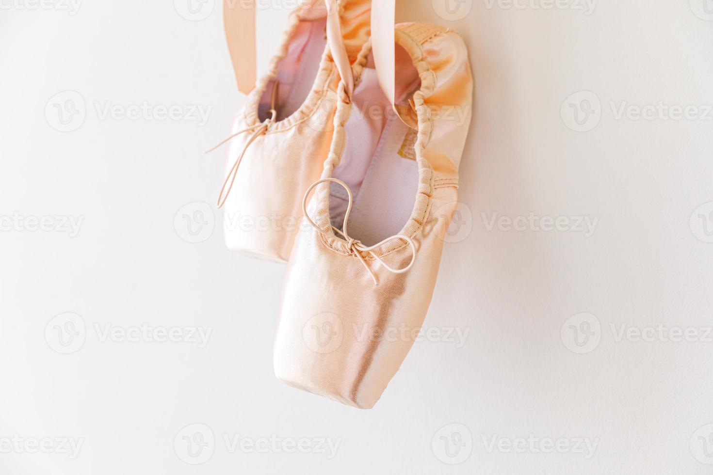 New pastel beige ballet shoes with satin ribbon isolated on white background. Ballerina classical pointe shoes for dance training. Ballet school concept, Copy space photo