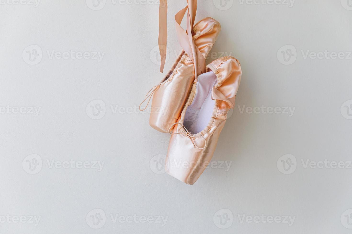 nuevos zapatos de ballet beige pastel con cinta de raso aislado sobre fondo blanco. Bailarina de punta clásica para entrenamiento de baile. concepto de escuela de ballet, espacio de copia foto