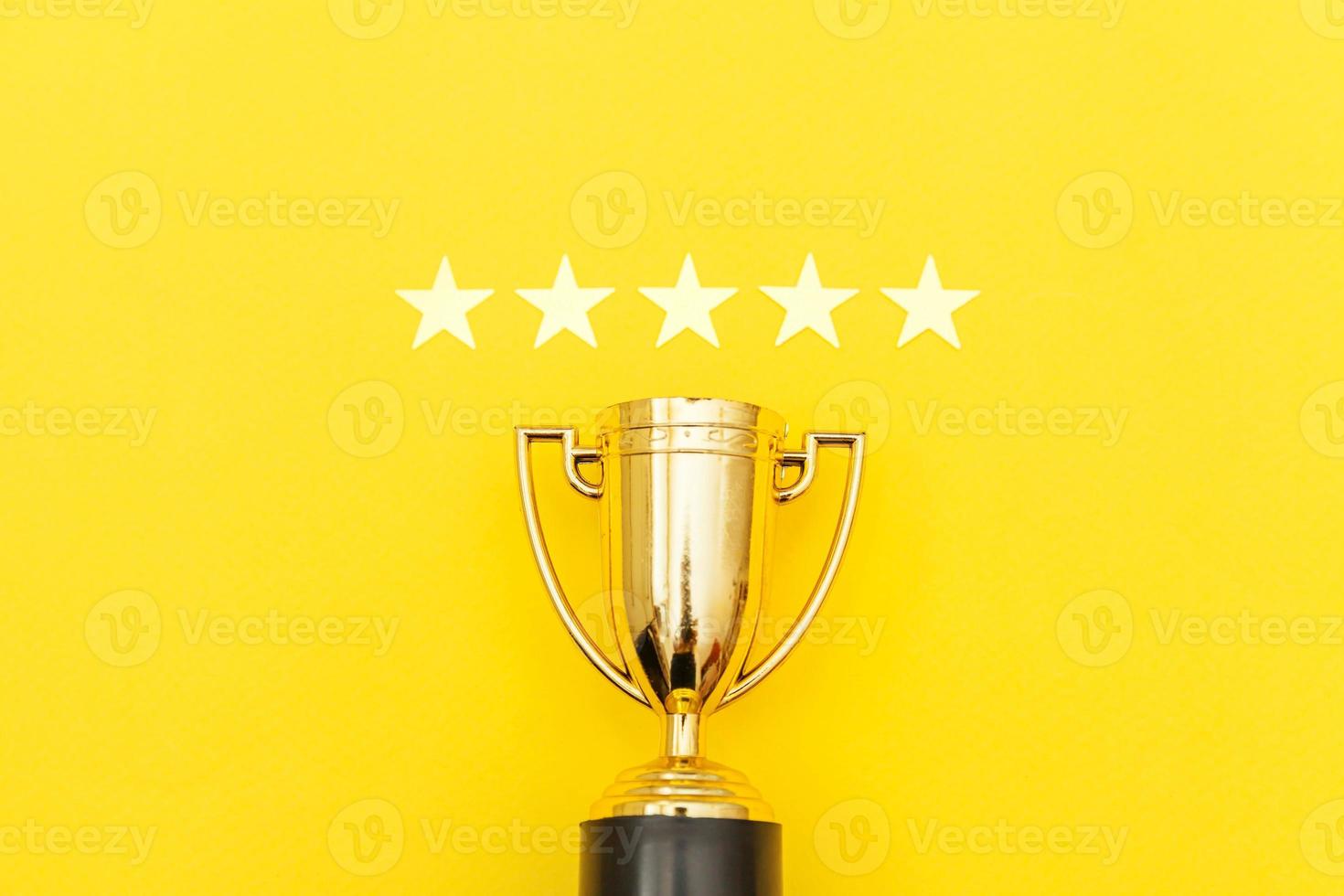 Simply flat lay design winner or champion gold trophy cup and 5 stars rating isolated on pink pastel background. Victory first place of competition. Winning or success concept. Top view copy space. photo
