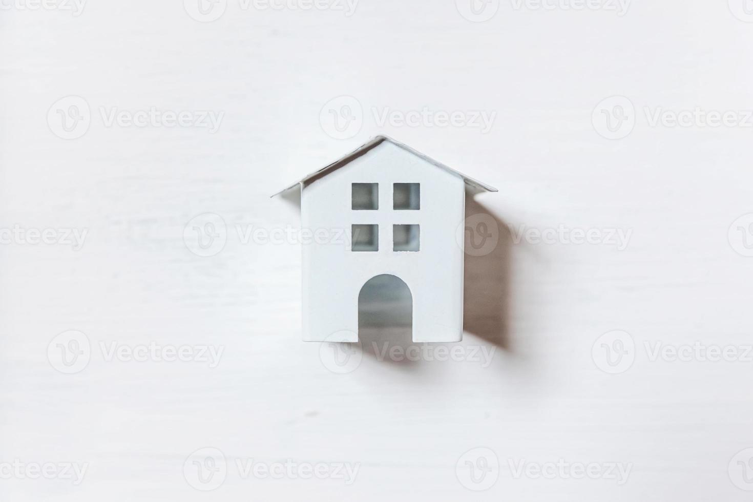 Simply minimal design with miniature toy house isolated on white background. Mortgage property insurance dream home concept. Flat lay top view, copy space photo