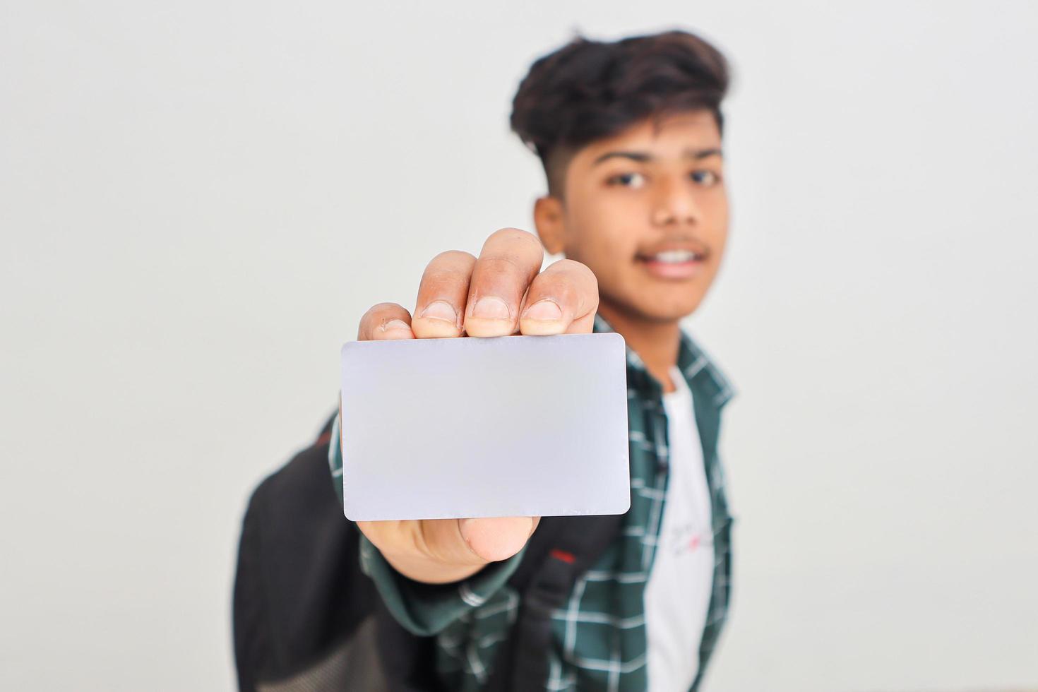 joven indio mostrando tarjeta de débito o crédito con fondo blanco. foto