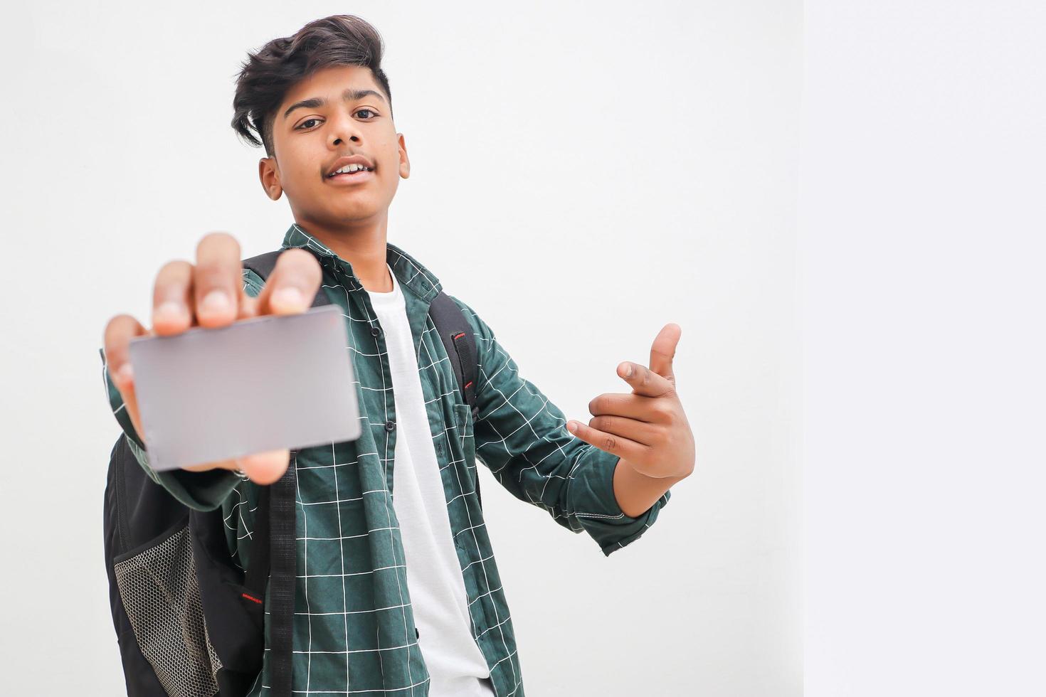 Young indian man showing debit or credit card on white background. photo