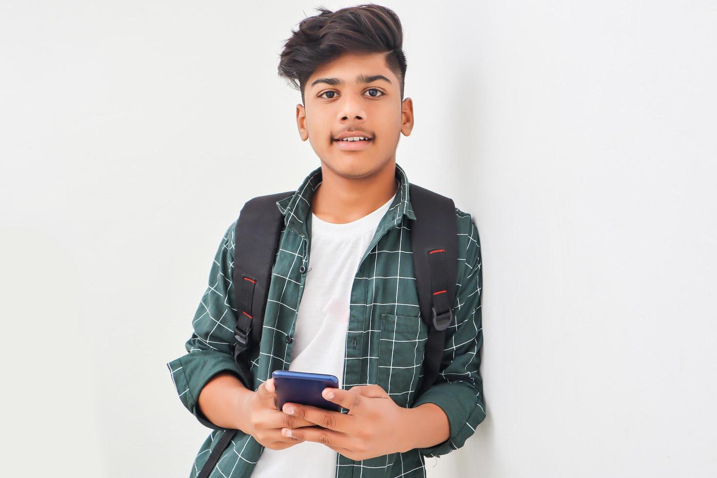 Indian college student using smartphone on white background. photo