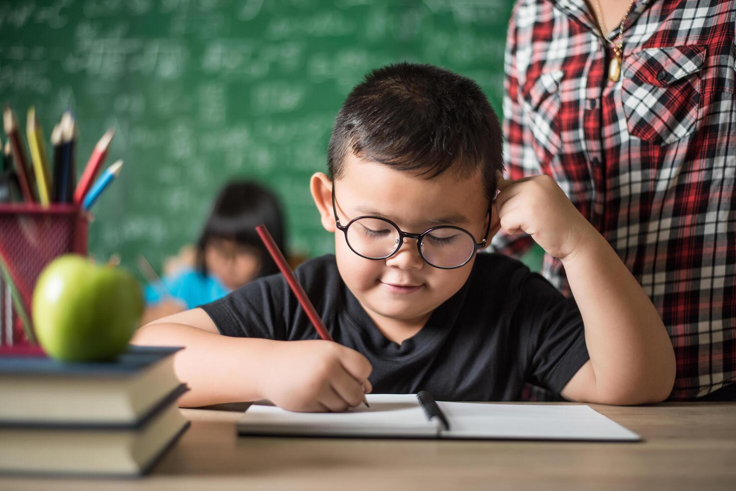 kid  write a book in the classroom. photo