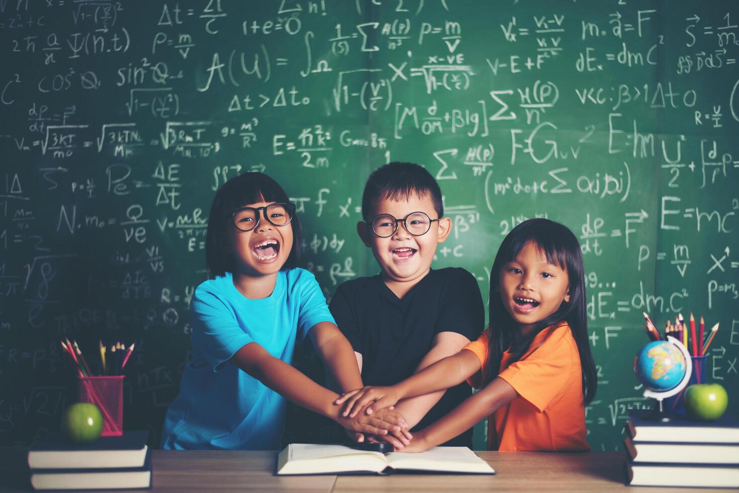 las manos de los estudiantes se apilan juntas en el aula foto