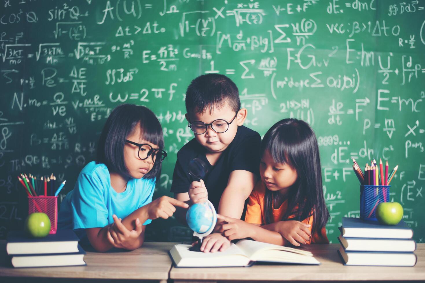 kid observing or studying educational globe model in the classroom. photo