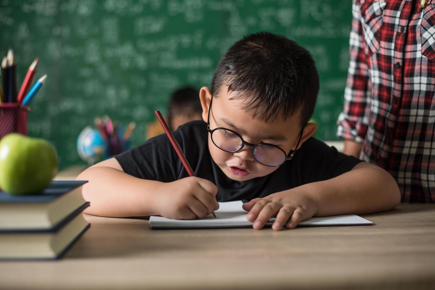 kid  write a book in the classroom. photo