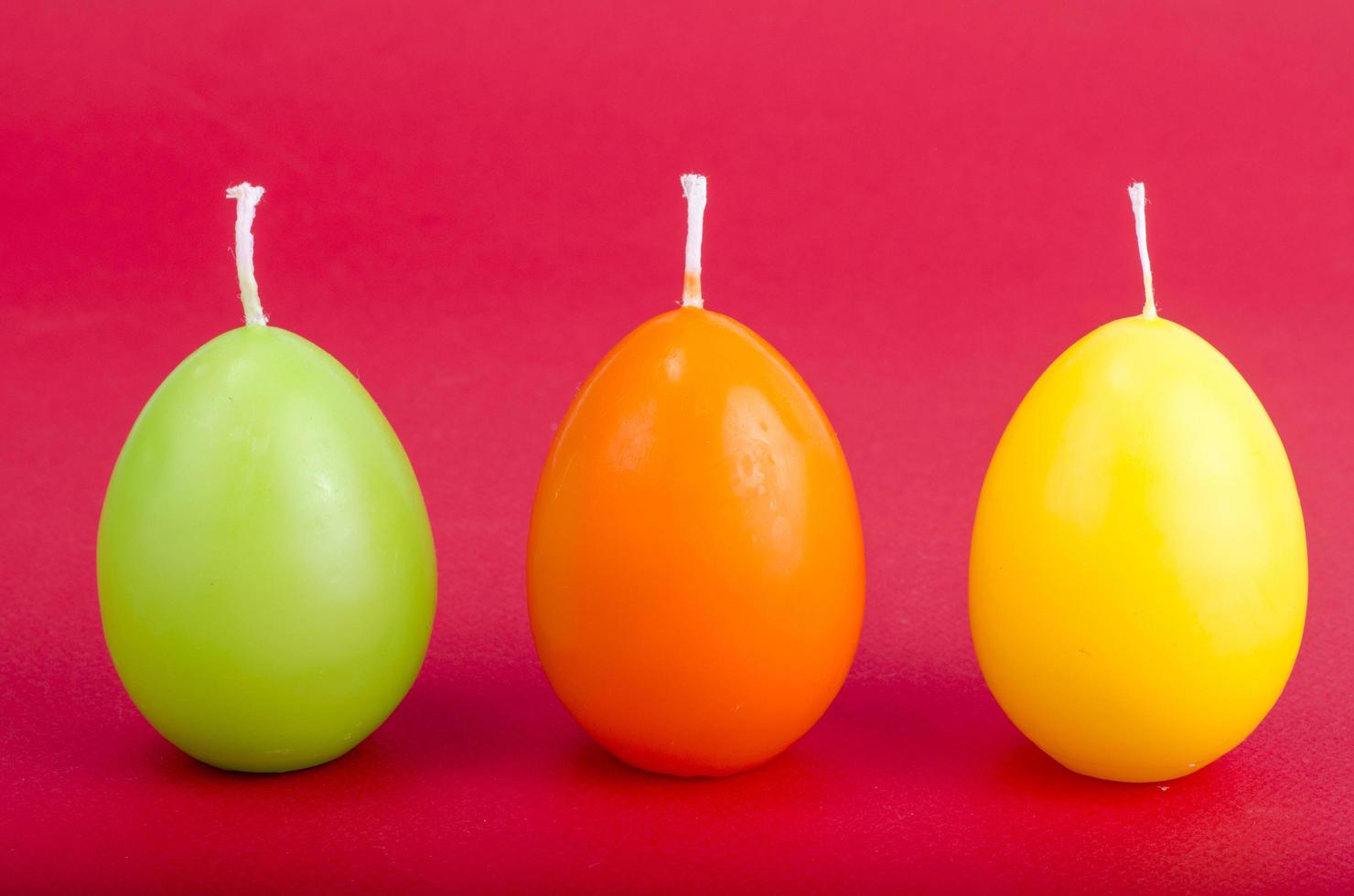 Bright colored decorative candles in shape of eggs. photo