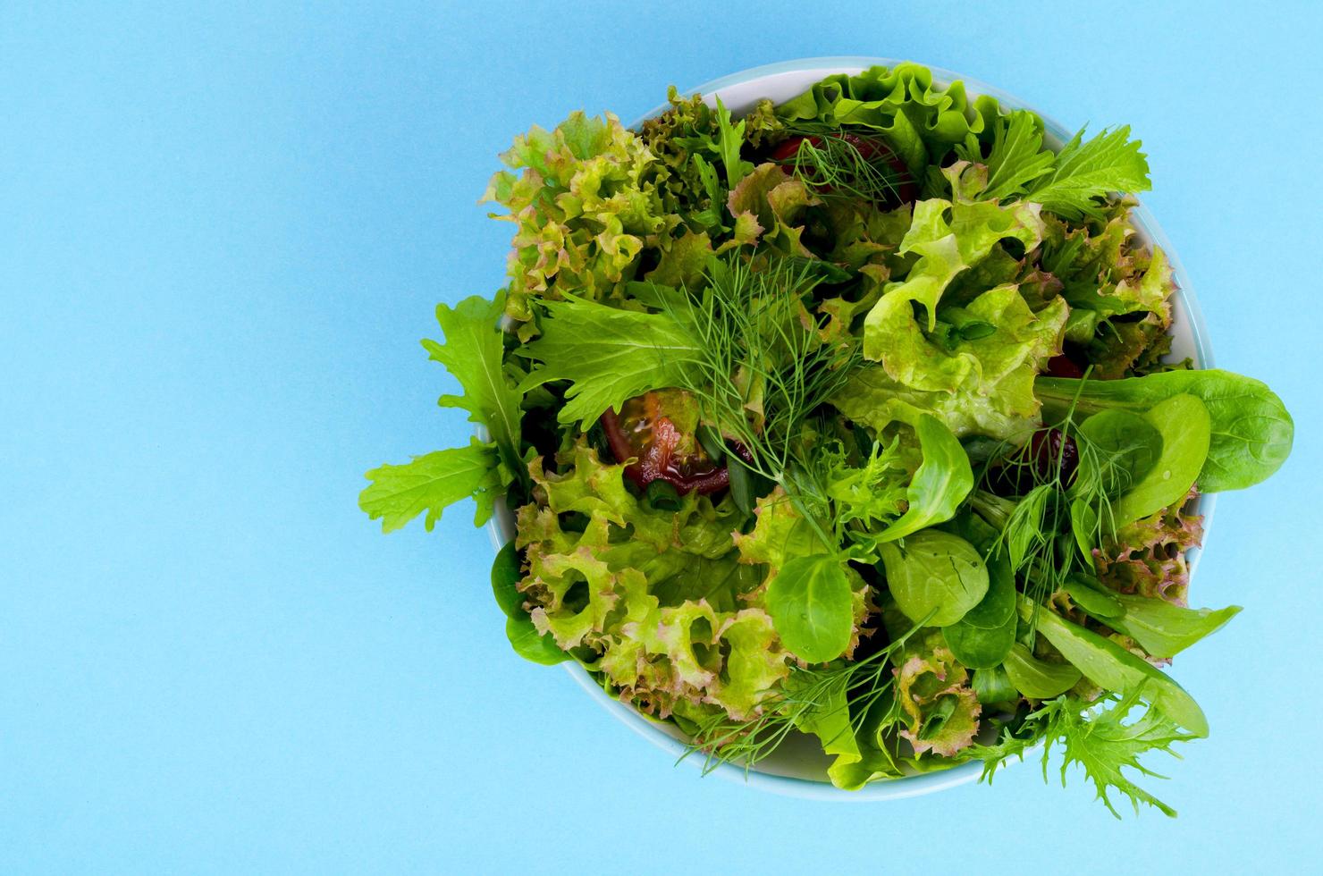 Bowl of mixed salad on bright, color background. photo