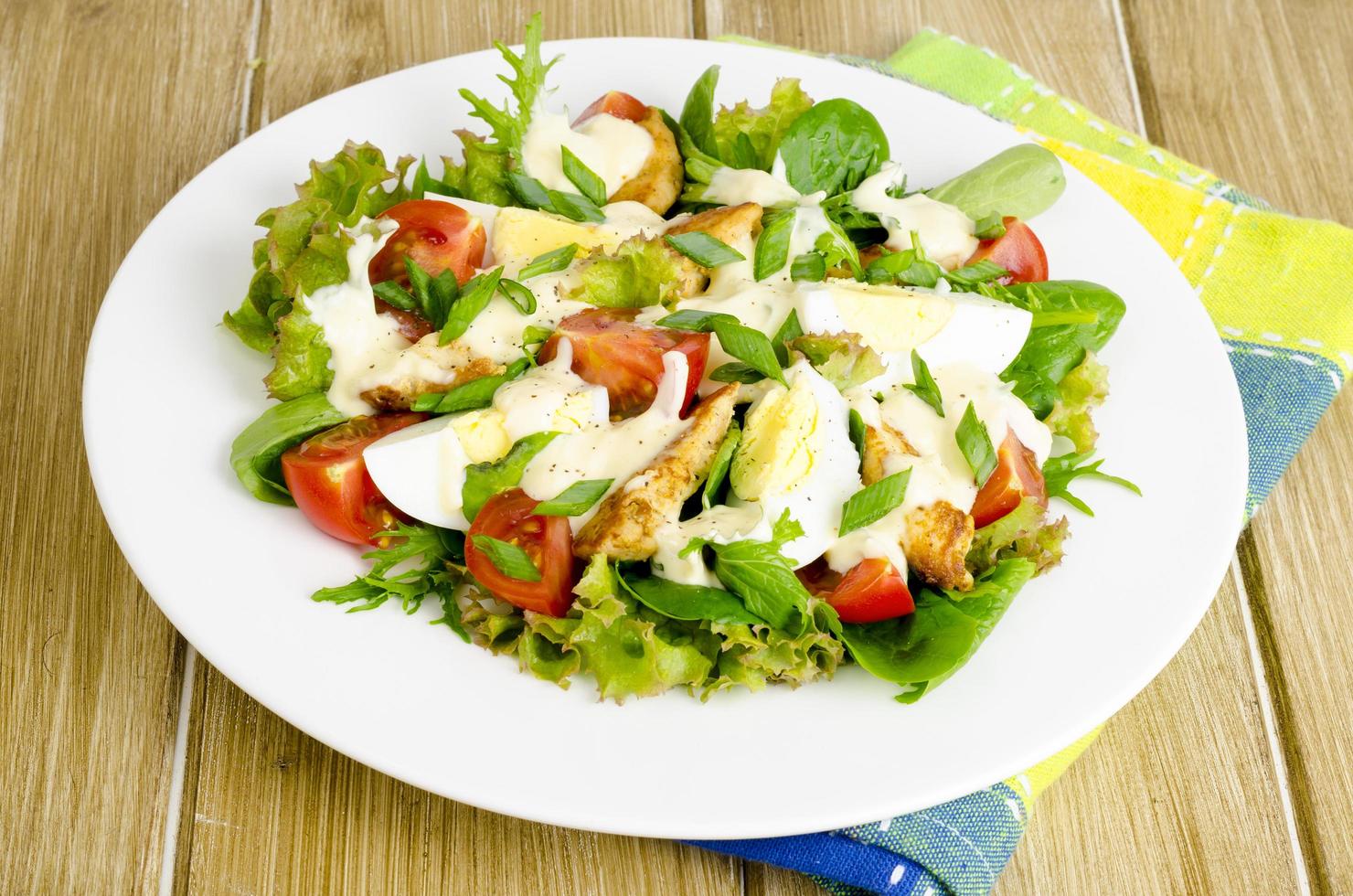 Salad of fresh vegetables, eggs, chicken meat with white sauce. photo