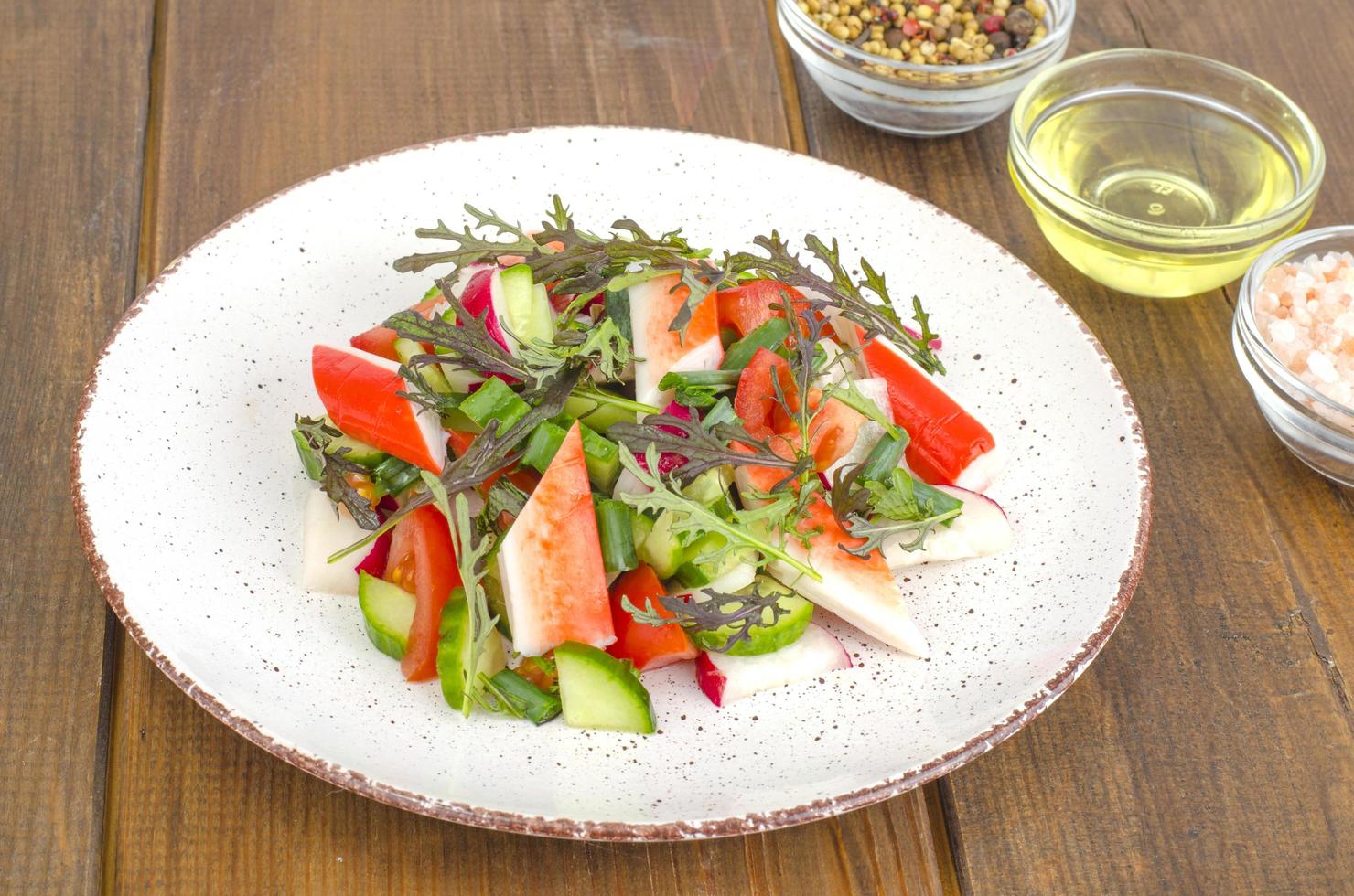 Fresh vegetable salad with crab sticks. photo