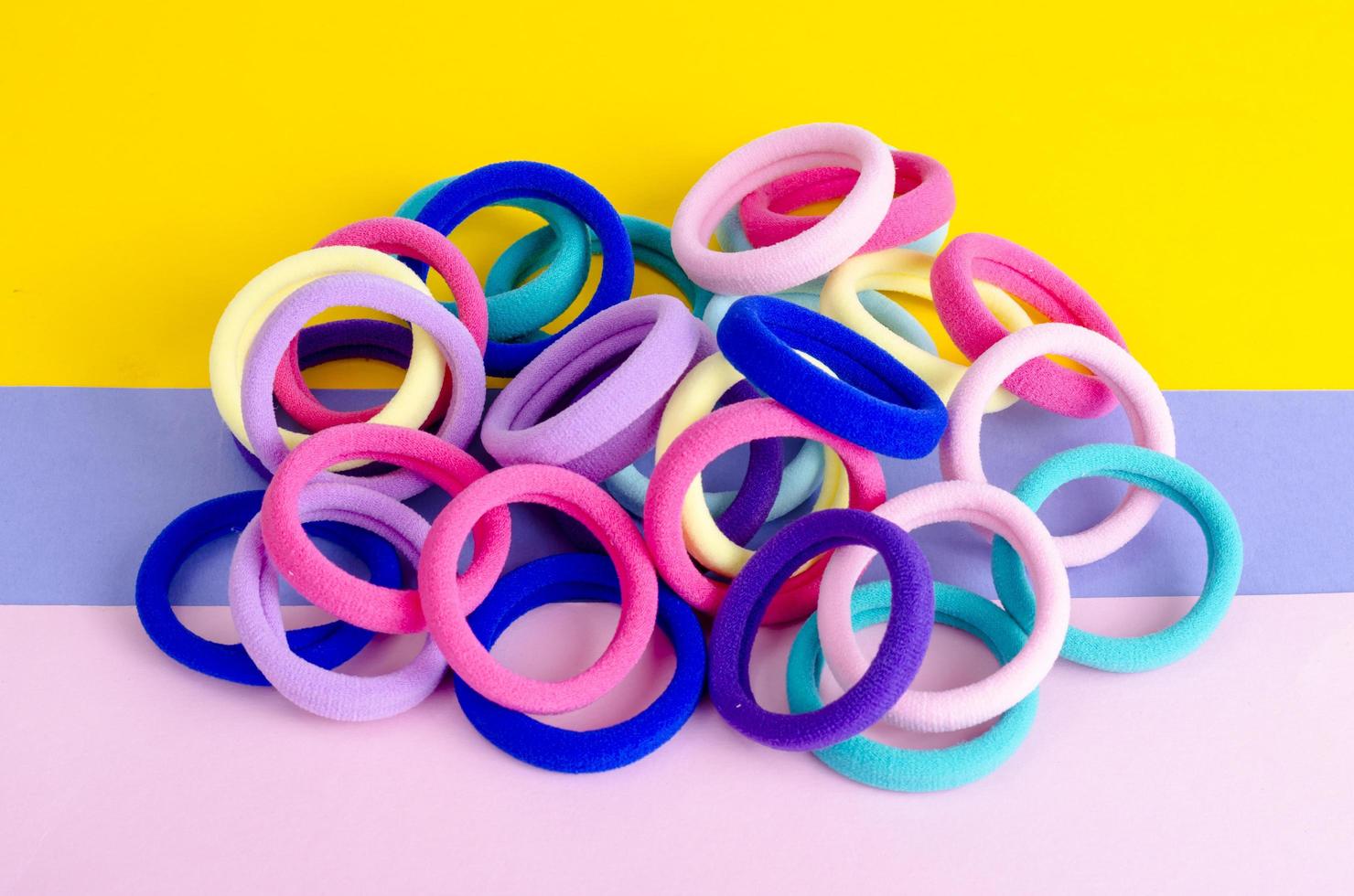 Colored hair ties on bright background. Photo