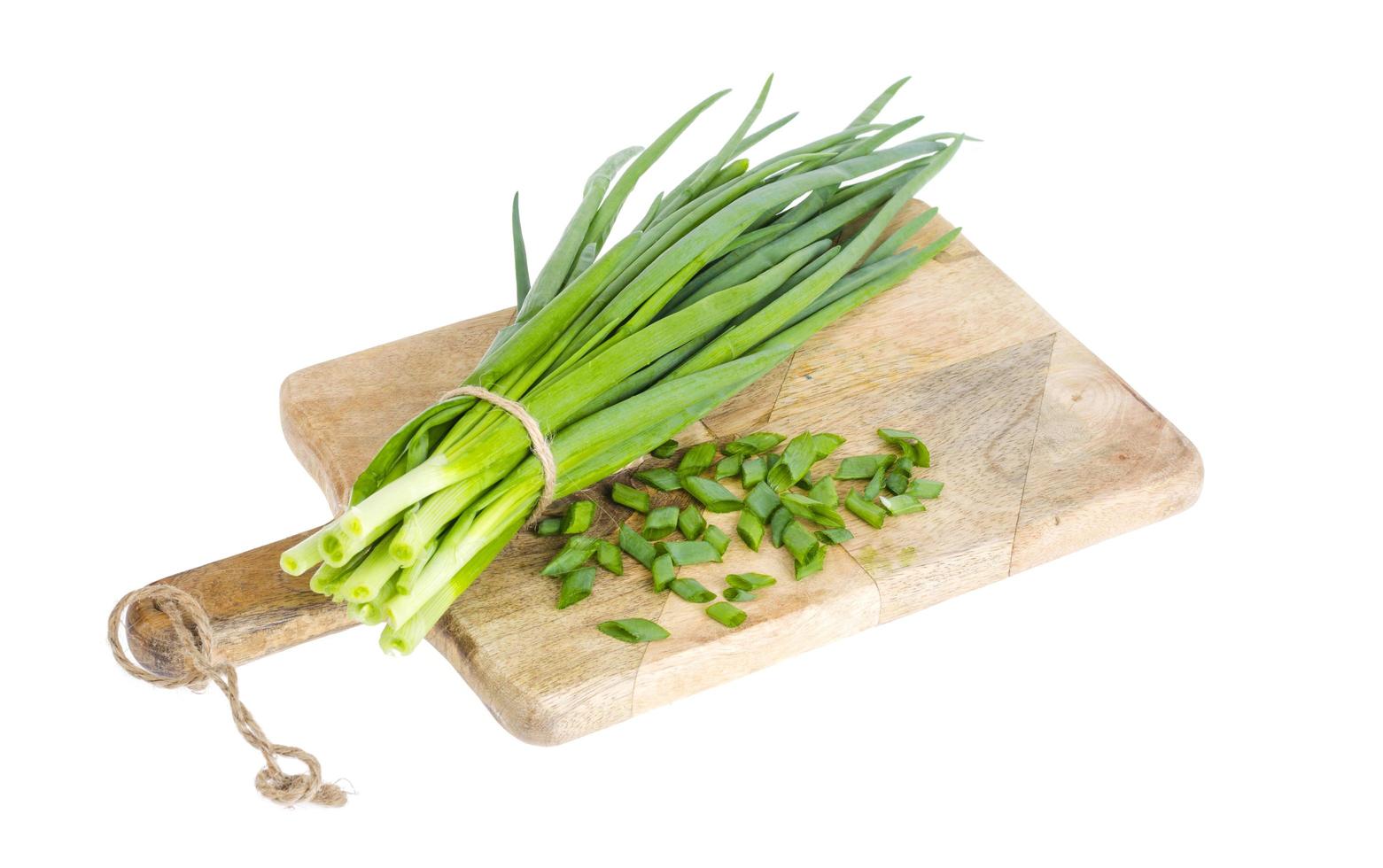 Use of fresh green onions in cooking, kitchen wooden board. photo
