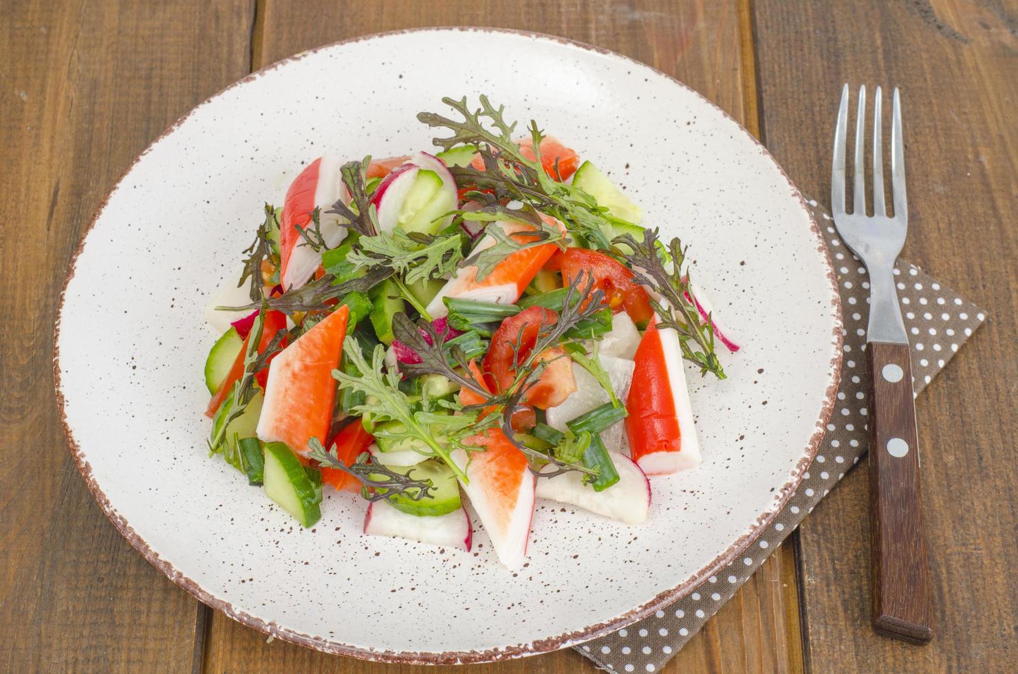 Fresh vegetable salad with crab sticks. photo