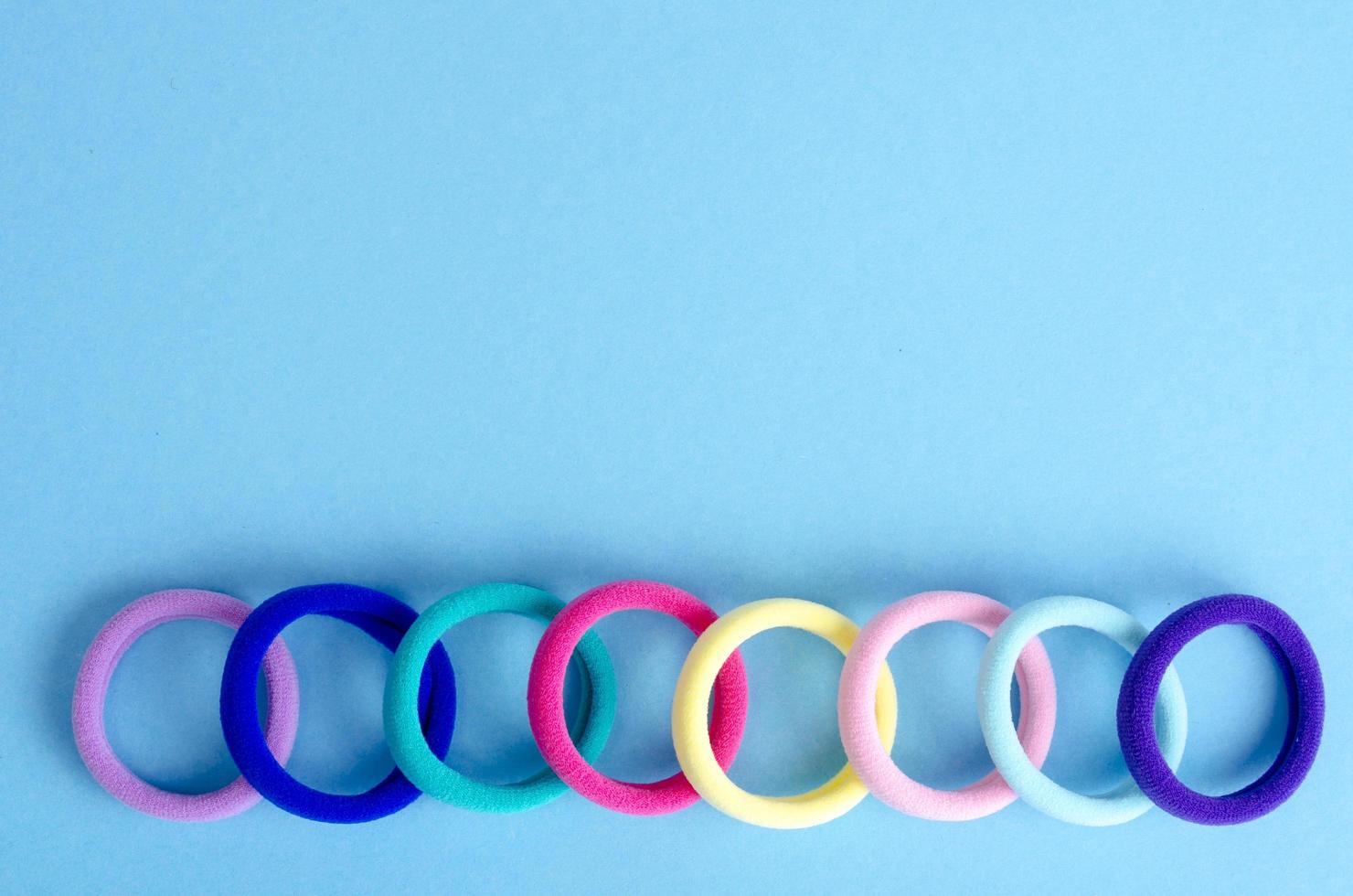 Colored hair ties on bright background. Photo