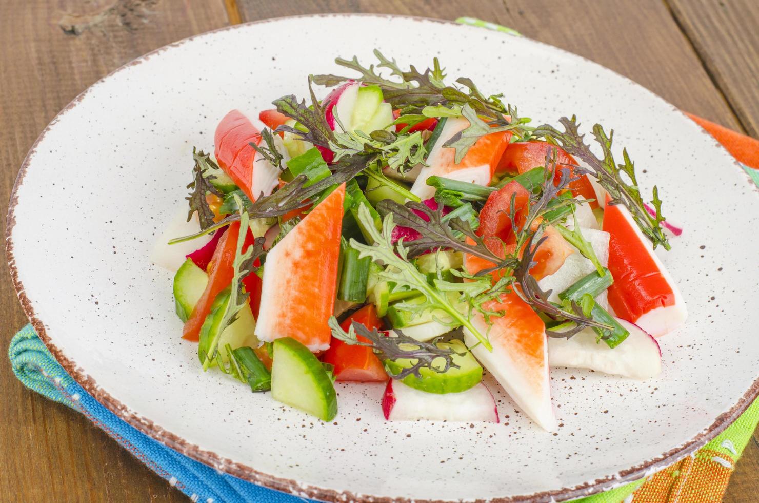 Fresh vegetable salad with crab sticks. photo