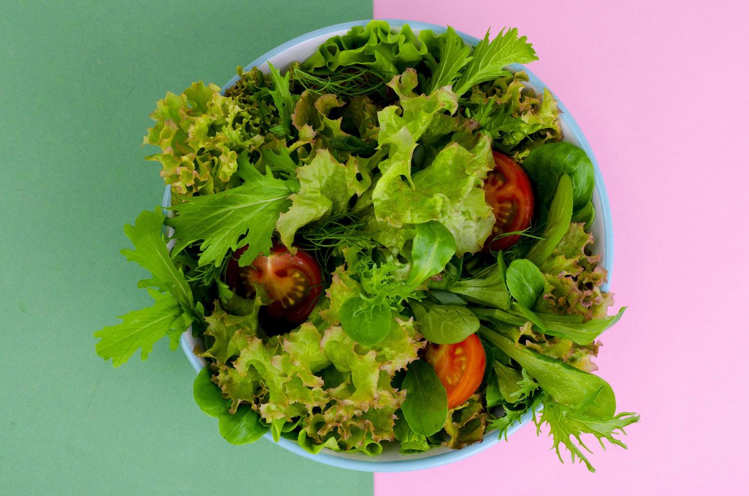 Bowl of mixed salad on bright, color background. photo