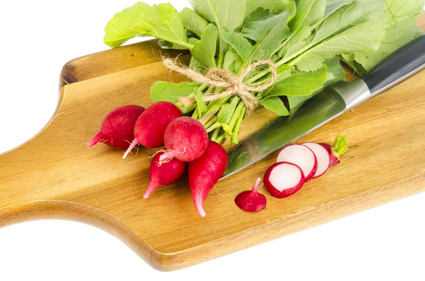 Bunch of fresh red radish on wooden cutting board for cooking. photo