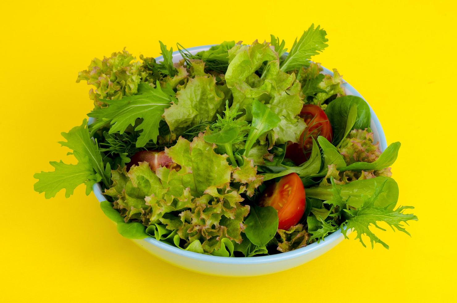 Bowl of mixed salad on bright, color background. photo