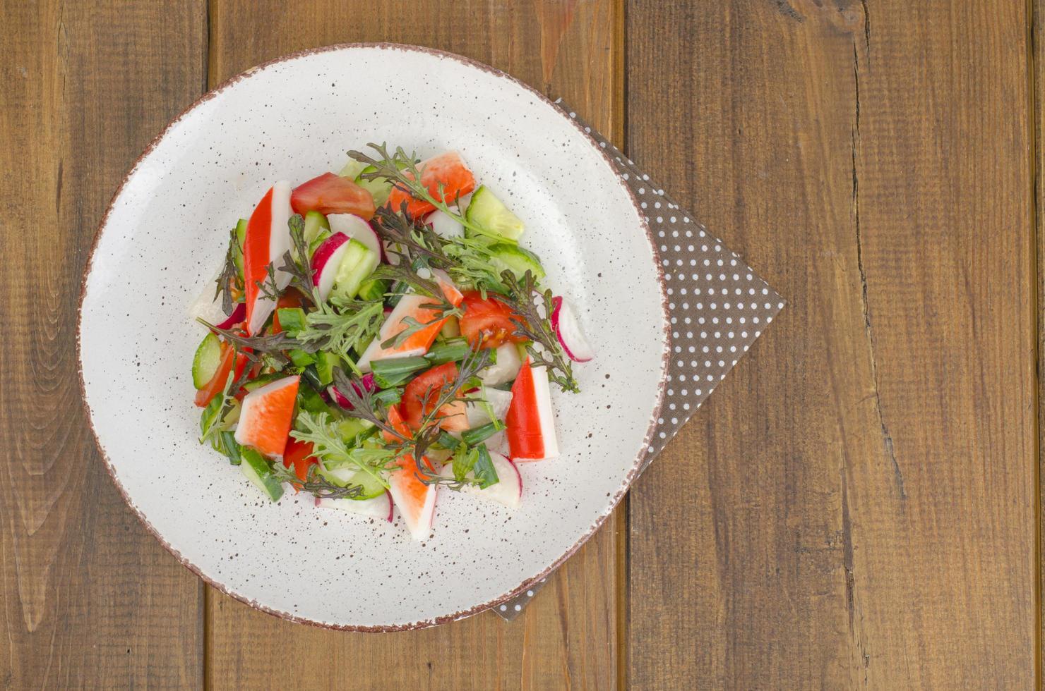 Fresh vegetable salad with crab sticks. photo