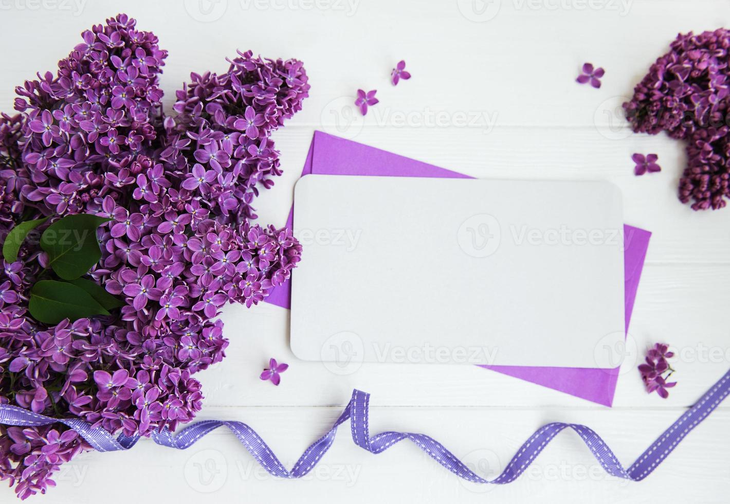 flores lilas con tarjeta de felicitación en una mesa foto
