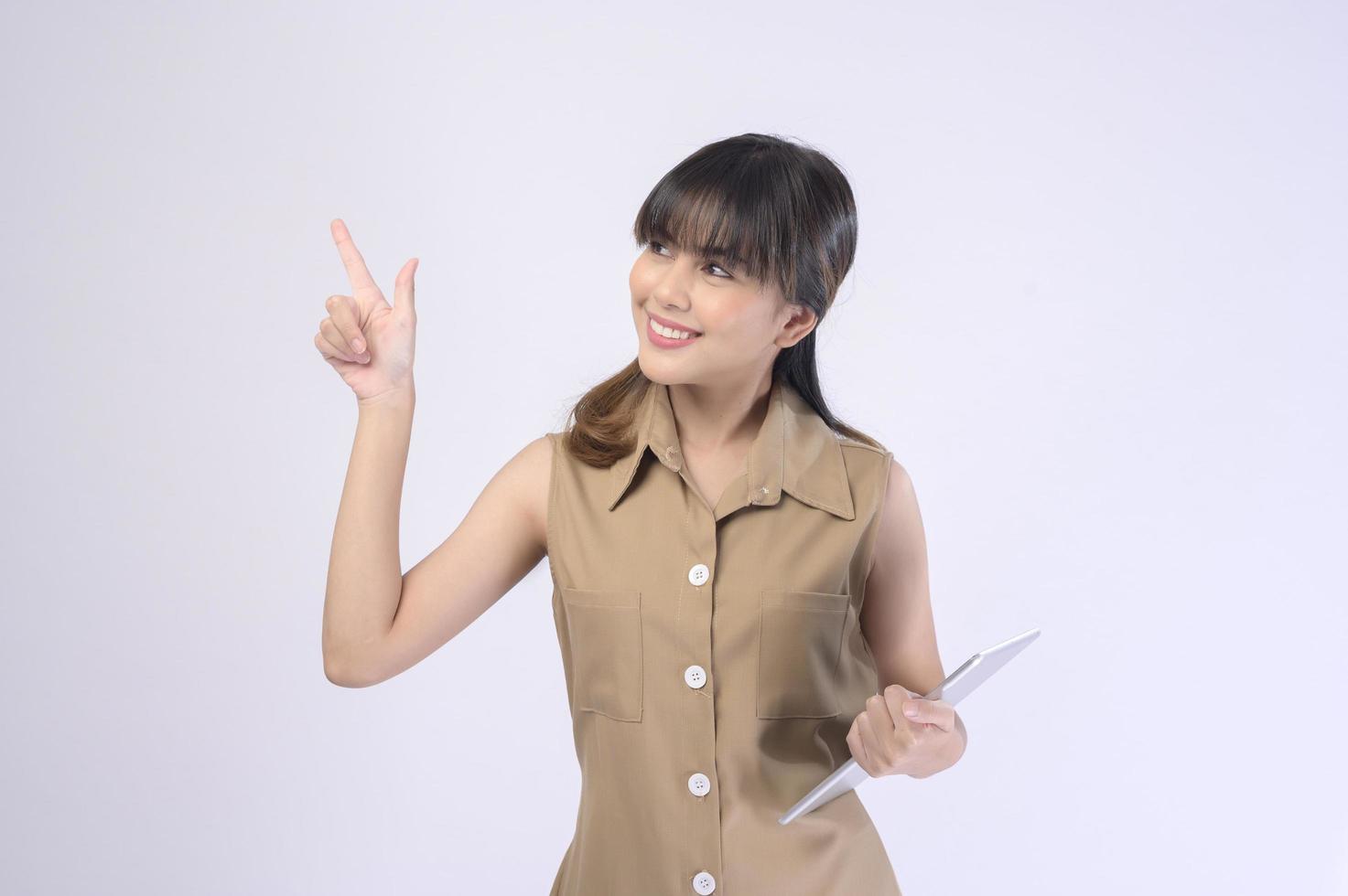 Portrait of young beautiful smiling woman is holding tablet over white background studio photo