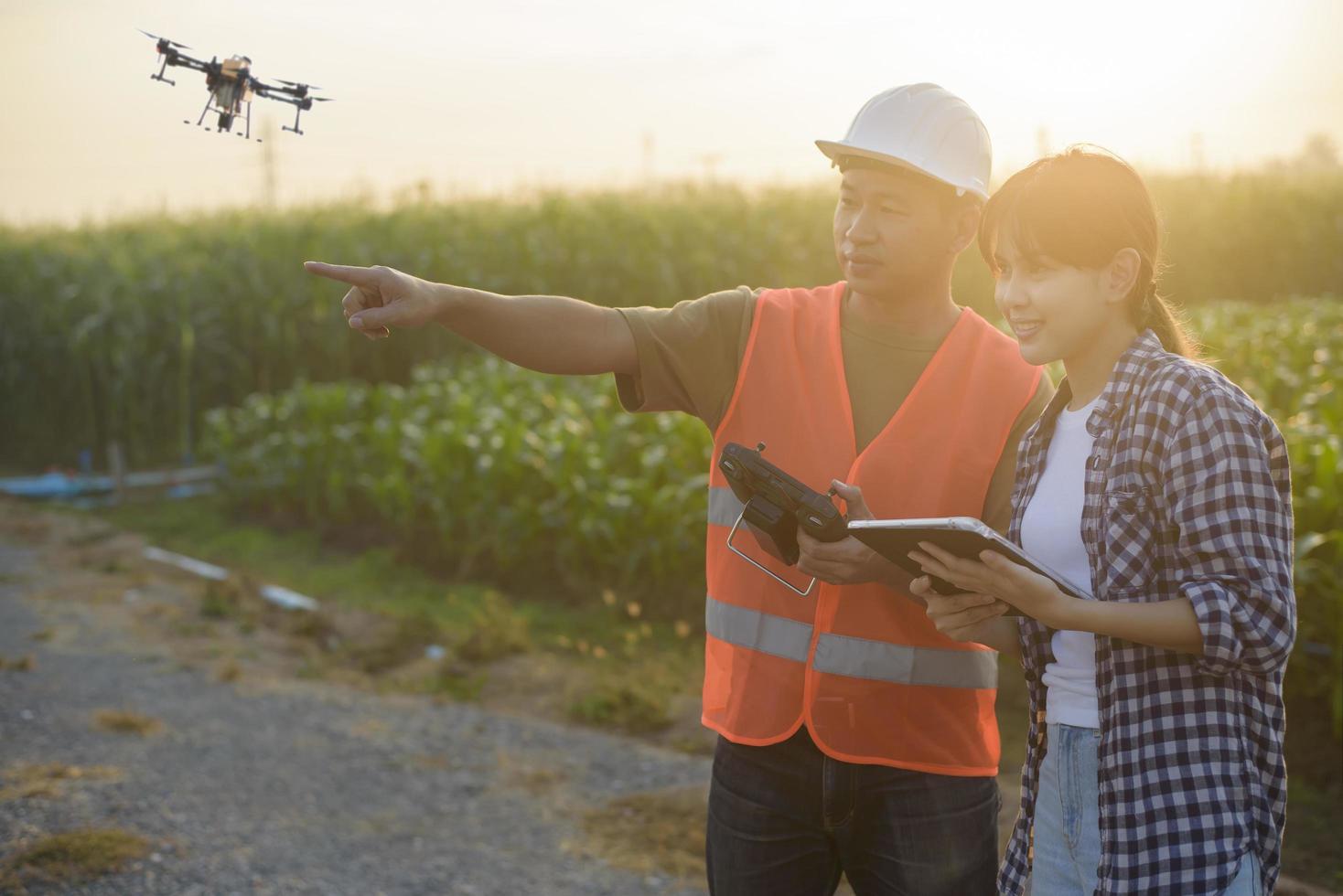 Male engineer  provide a consultation and instructing to smart farmer with drone spraying fertilizer and pesticide over farmland,High technology innovations and smart farming photo