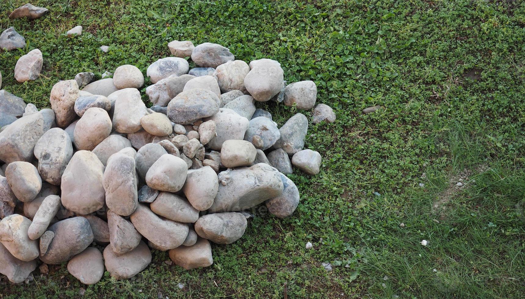 heap of stones on the grass photo