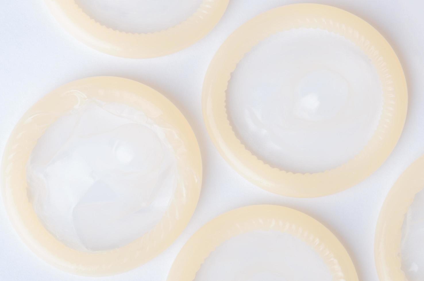 Rolled latex condom on white background photo