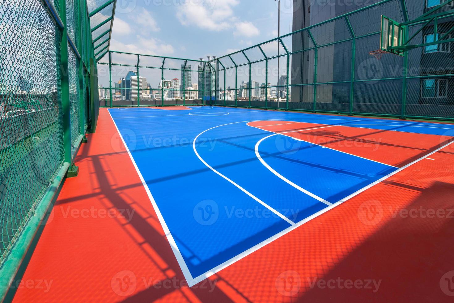 campo de baloncesto en edificios de gran altura en la ciudad. foto