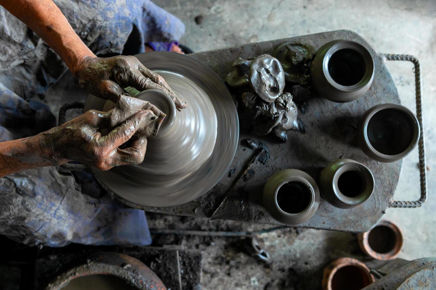 Top view of human hands working on pottery wheel at the workshop photo