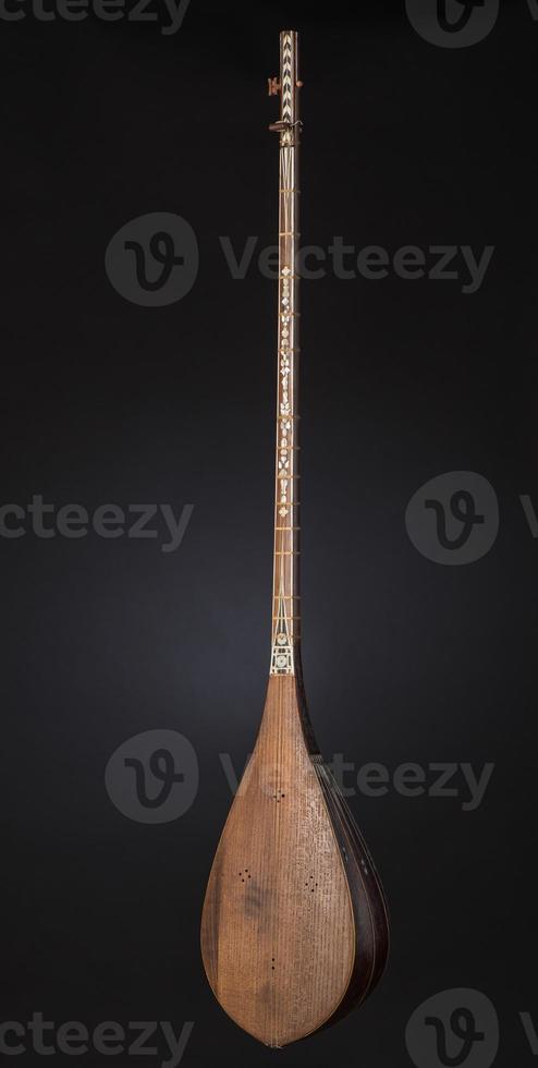 ancient Asian stringed musical instrument on black background with backlight photo