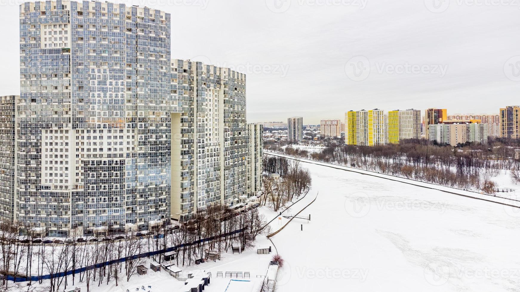 A view of flying with a quadcopter along an icy river and high-rise buildings photo
