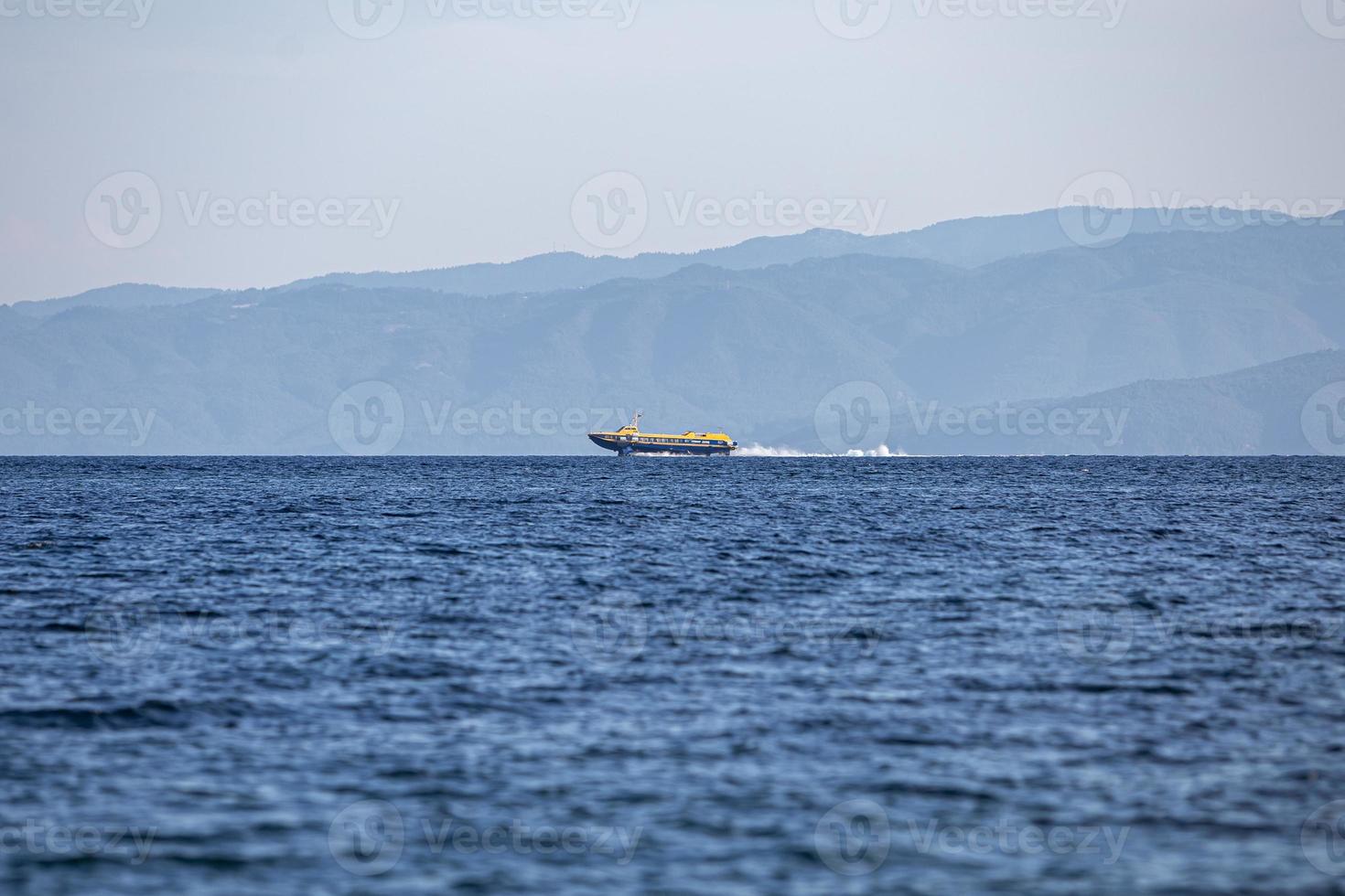 Speed boat, cruising at calm sea against a blue sky. photo
