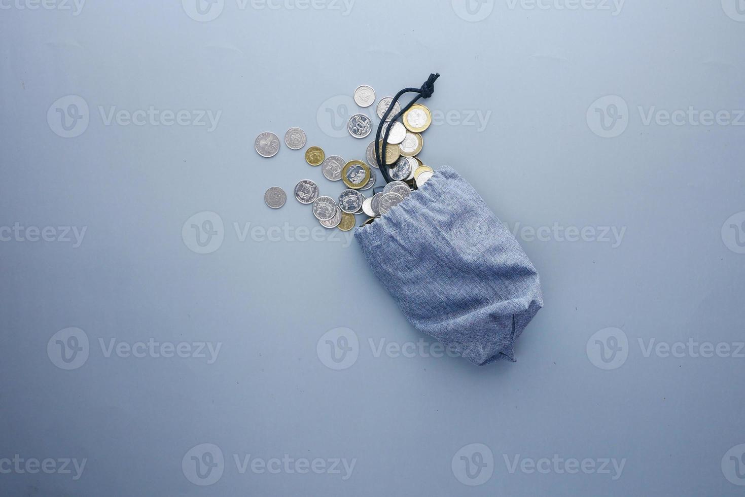 top view of coins spilling from a small bag photo