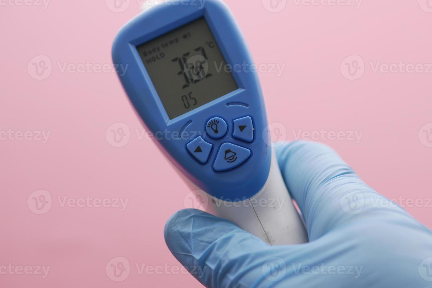Hand holding infrared thermometer to measuring temperature. photo