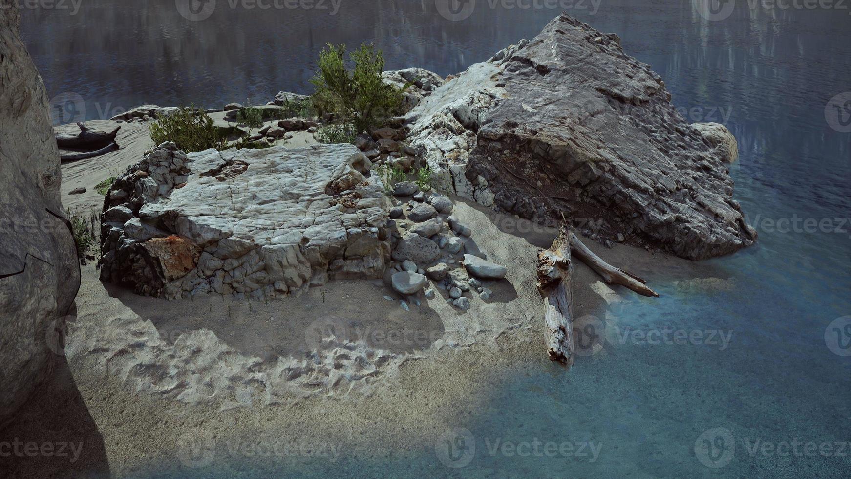 small sand ocean beach near rocky cliff photo