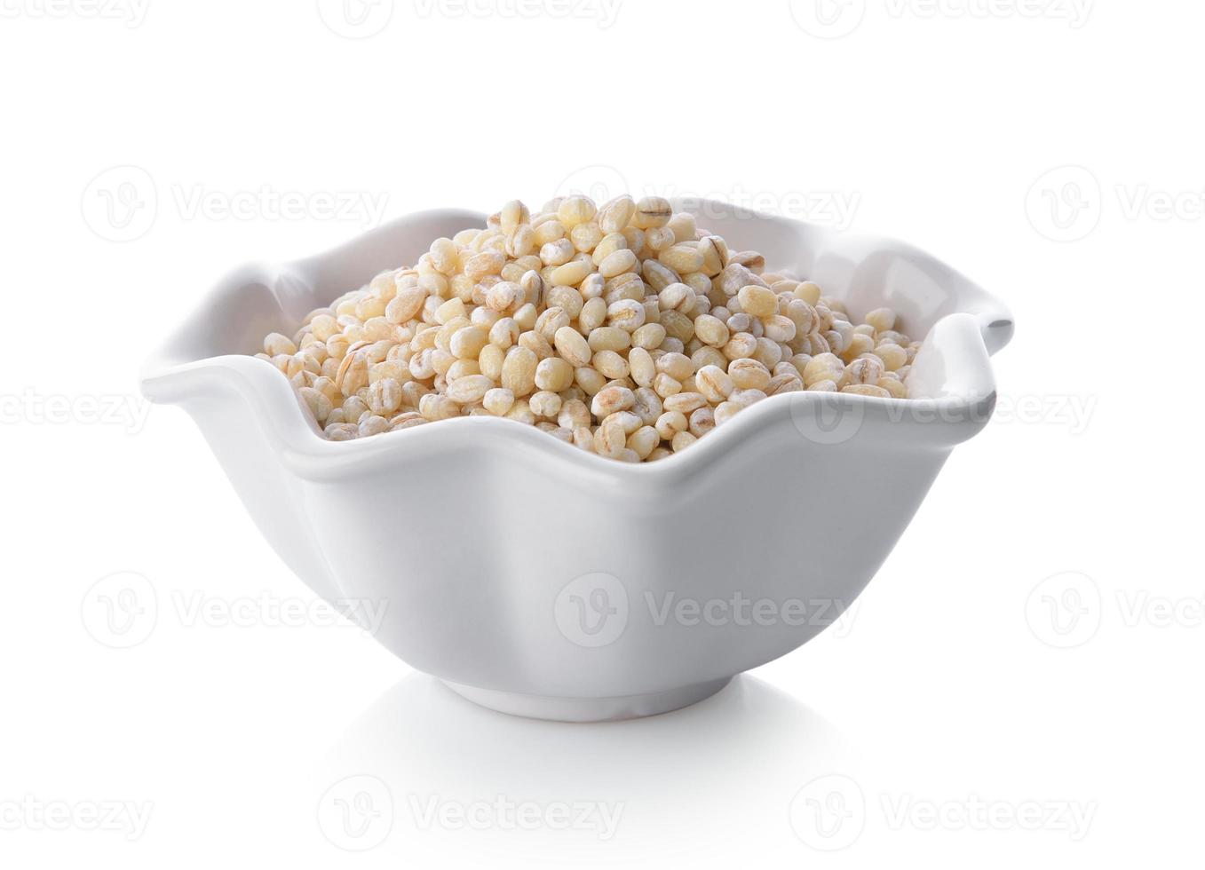 Heap of pearl barley in a bowl on white background photo