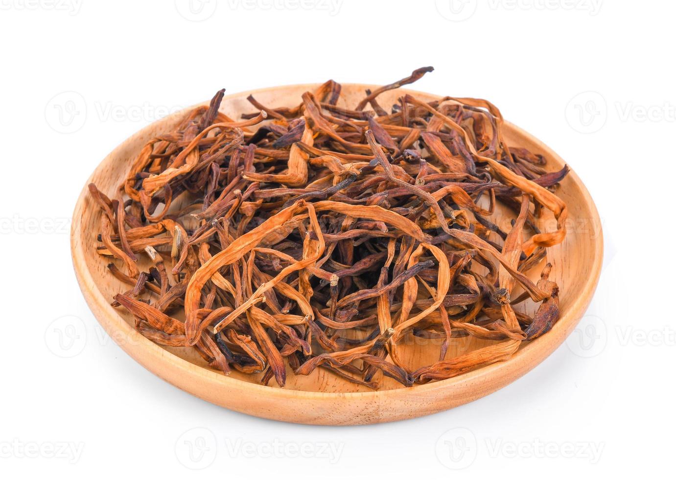 dried day lily flower in wood plate on white background photo