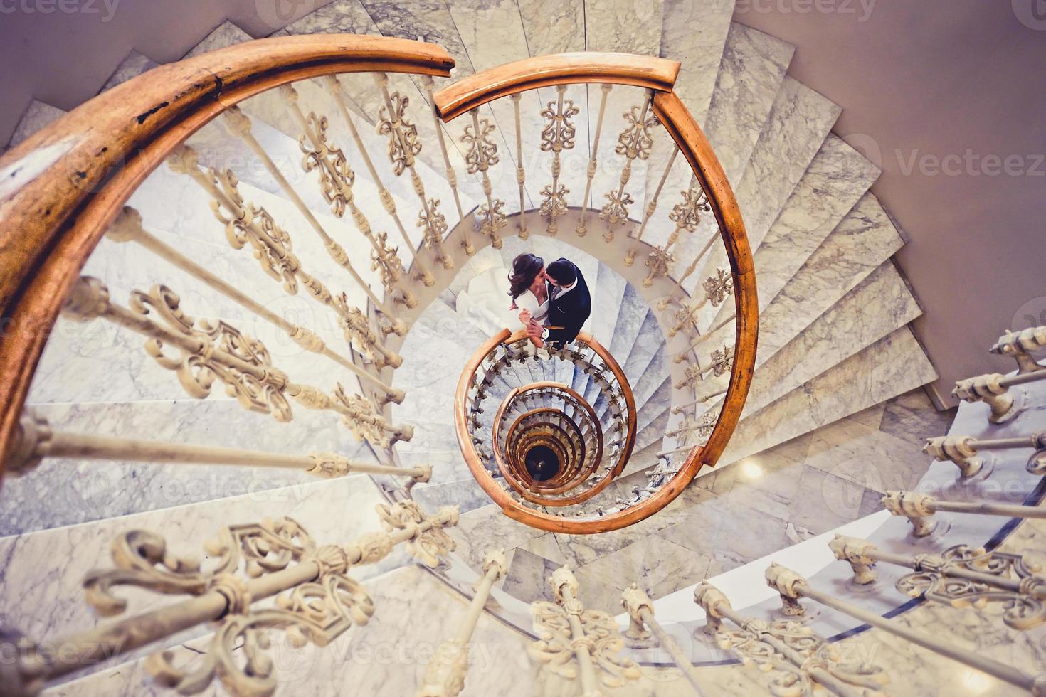 pareja de recién casados en una escalera de caracol foto