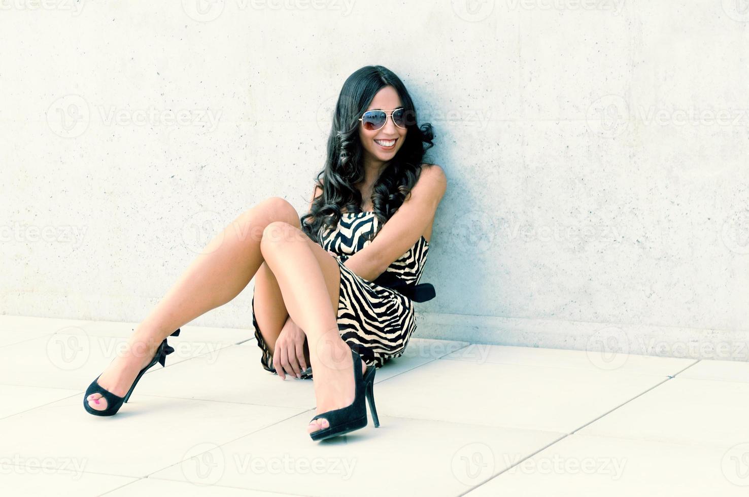 Funny Female model at fashion with high heels sitting on the floor photo