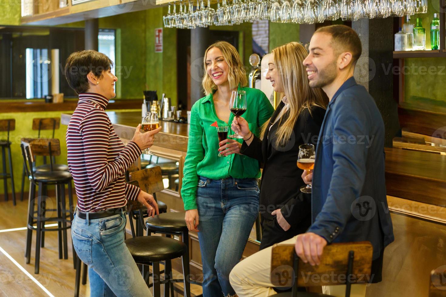 Happy friends chatting in a beautiful bar photo