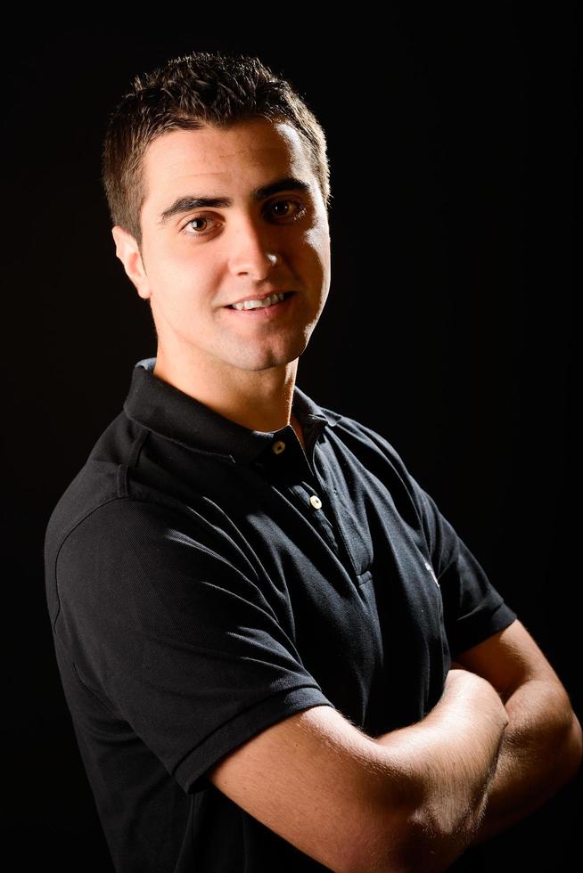 Young casual man on black background photo