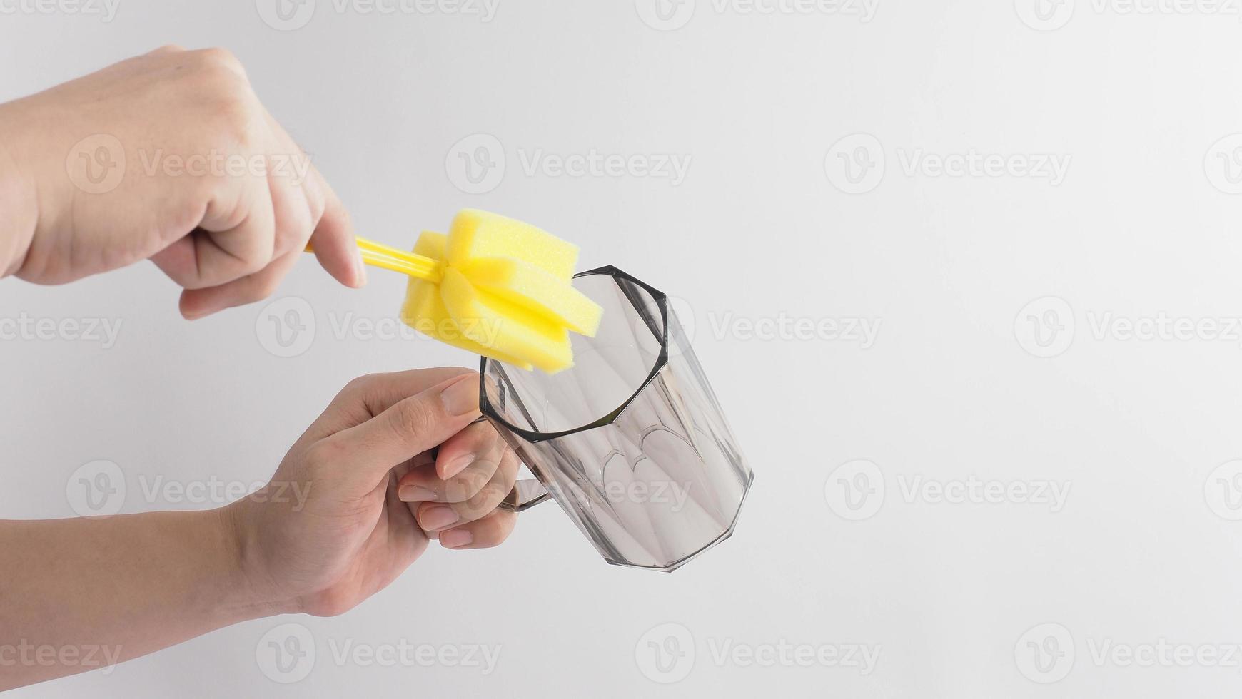 concepto de plato limpio y lavado. vaso de bebida de lavado de manos de hombre sobre fondo blanco. foto