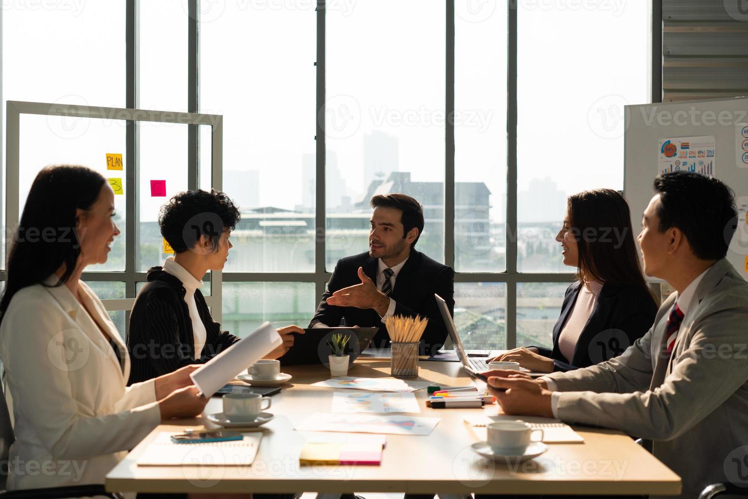 multiehthnic business team including caucasian and asian people  discussing about new project in office. diversity teamwork concept photo