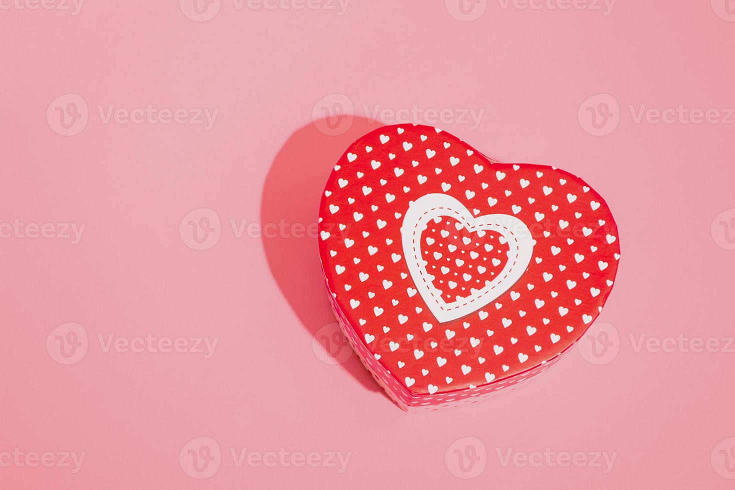 Heart shaped box mockup with hard shadow on red background. Closeup copy space photo