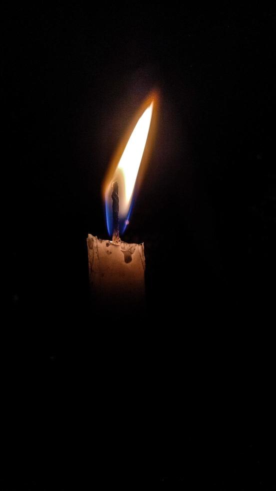 Candle in the dark and black background photo