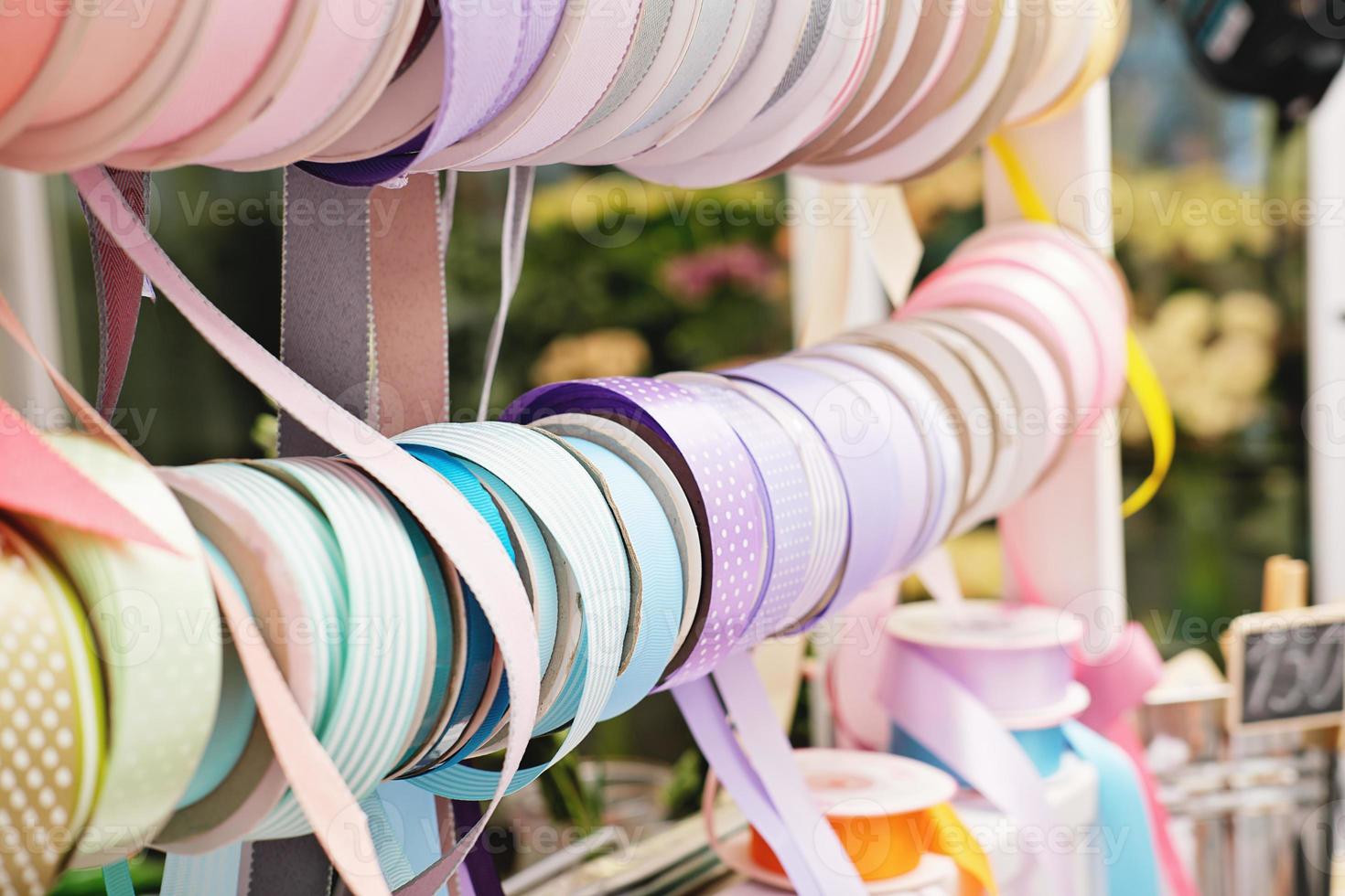 gift wrapping ribbons on a counter in a flower shop. various colors of ribbons for presents. gifts for holidays. small business, photo