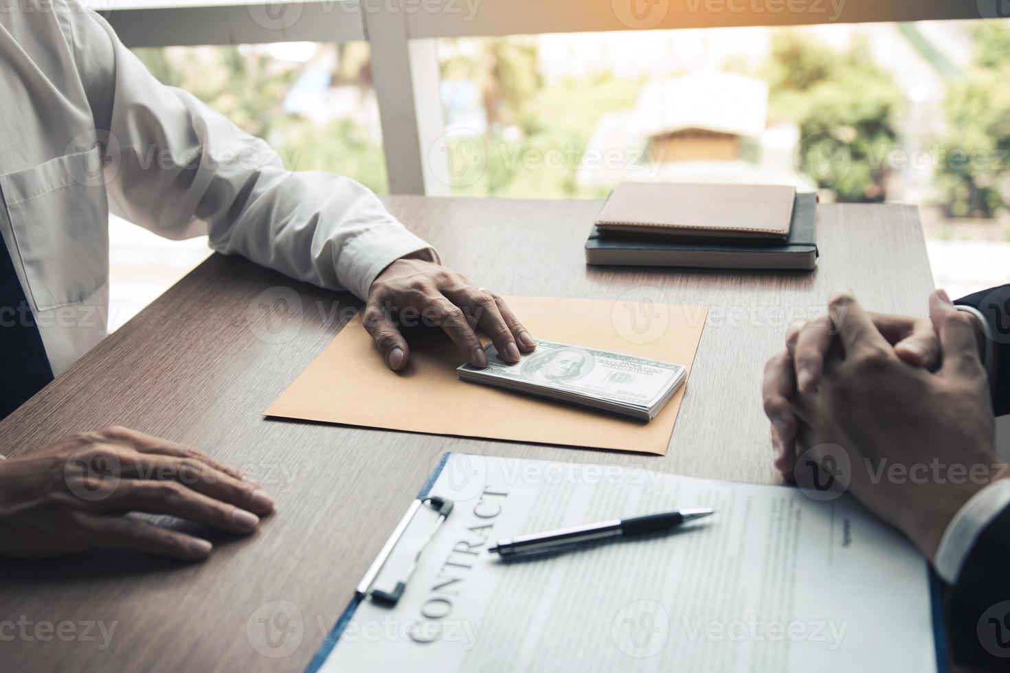 Partner has made a fraud in the contract of sale and being handed a cash and pen to the businessman signing the contract corruption bribery concept. photo