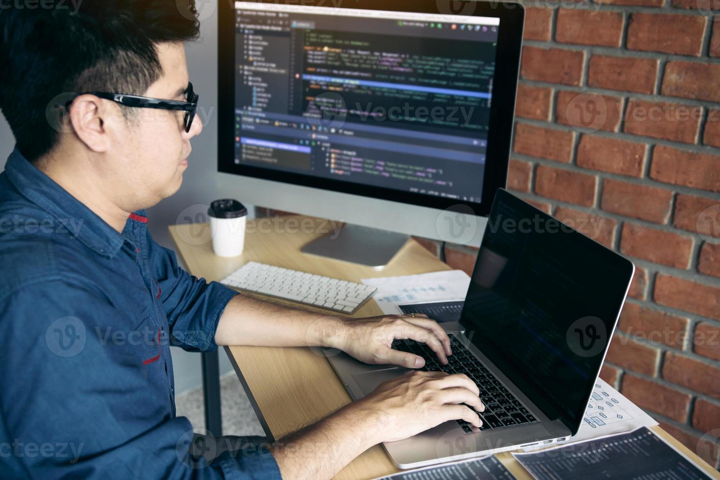Asian man working code program developer computer web development working design software on desk in office. photo